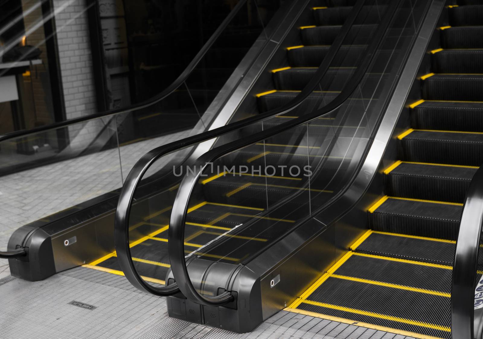 Empty escalators stairway with a yellow stripes