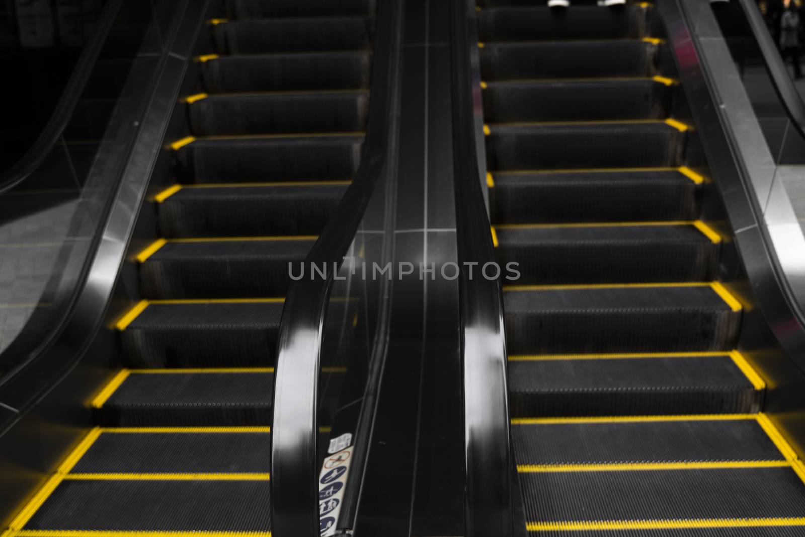 Empty escalators stairway with a yellow stripes