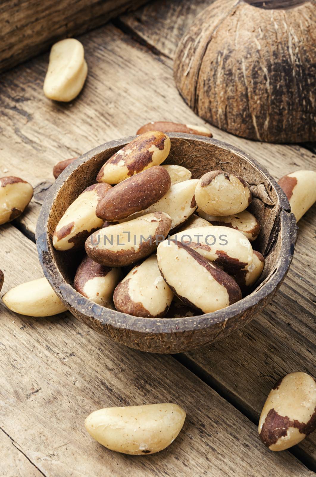 Tasty peeled brazil nut in bowl on old wooden table