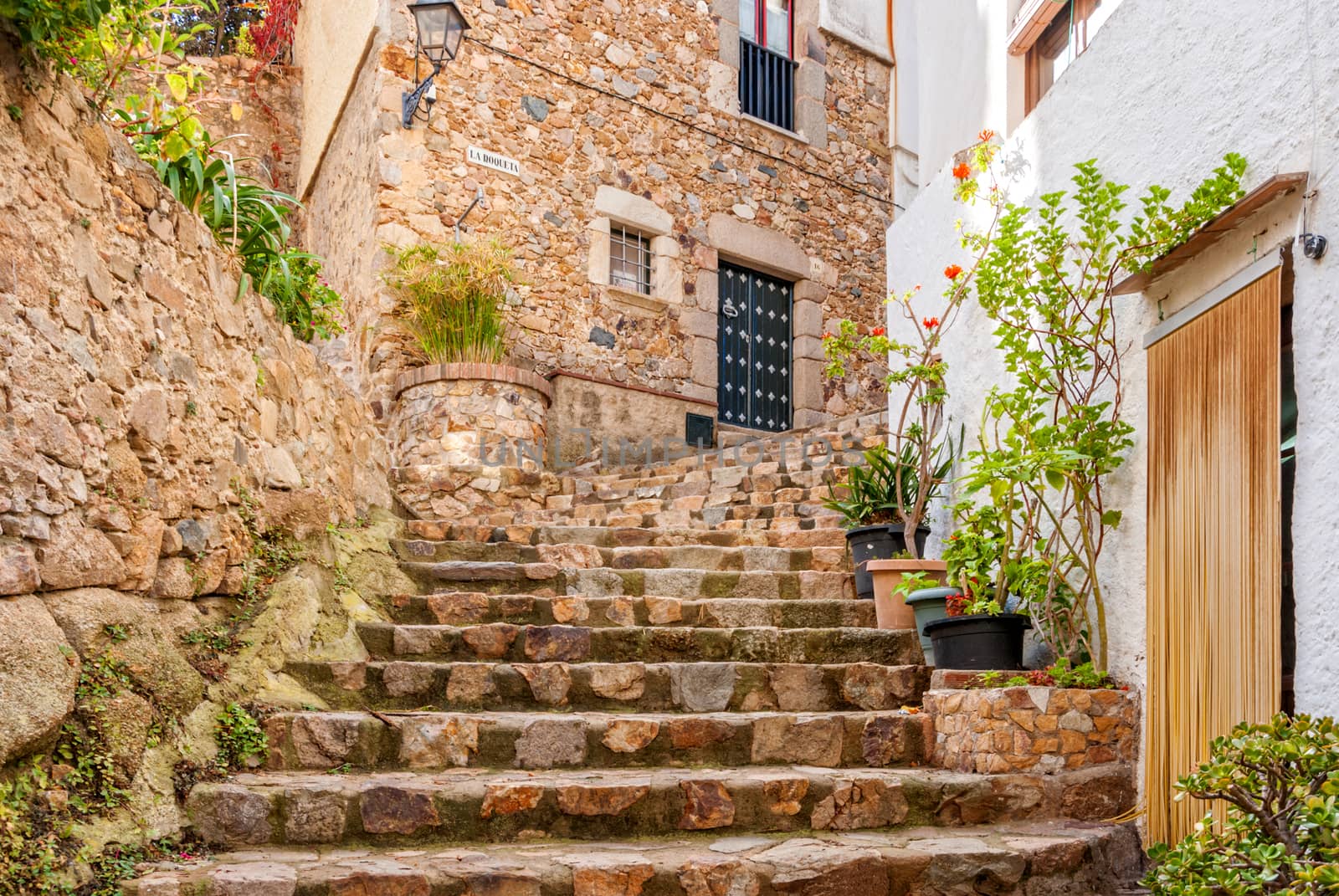 Spain, Tossa de Mar, cobbled street, staircase and stone wall in medieval Old Town - Vila Vella.