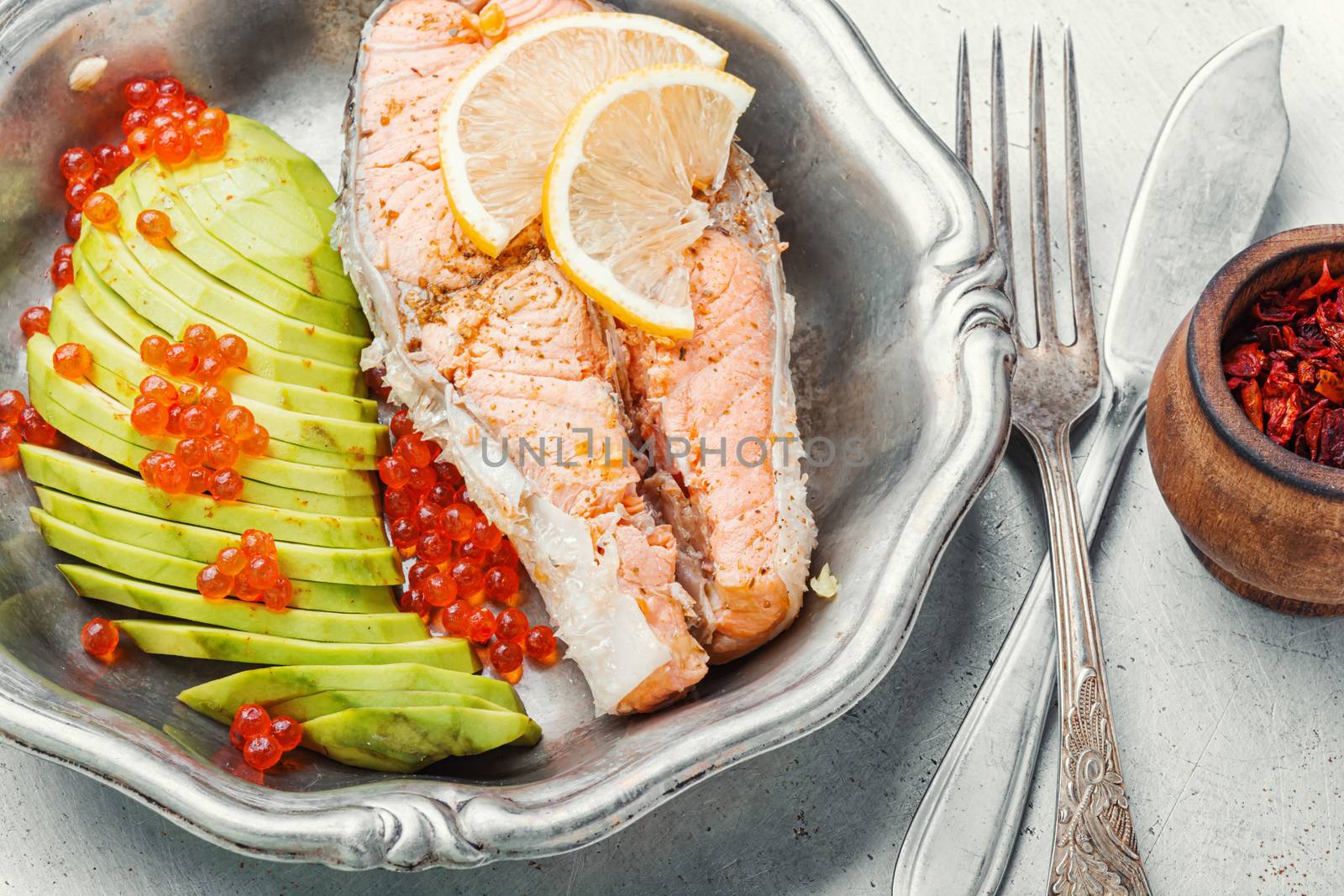 Boiled salmon or trout with avocado garnish.Diet fish.