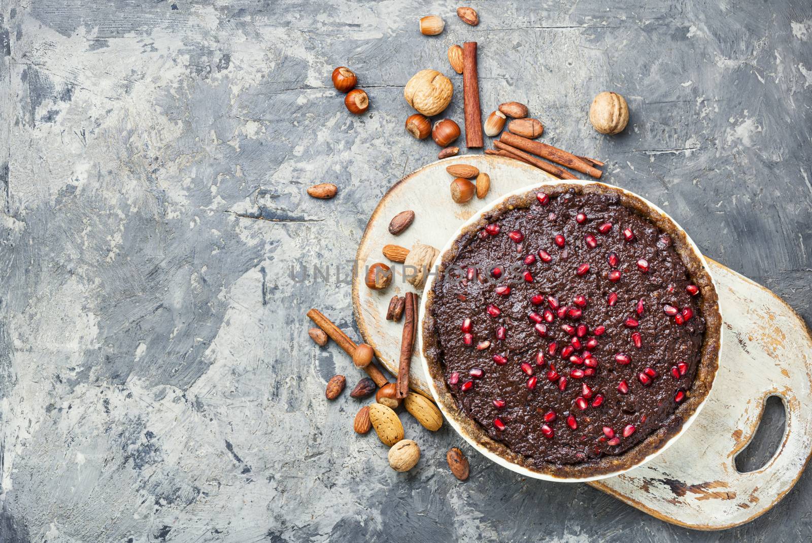 Tasty homemade chocolate cake with pomegranate and nut.