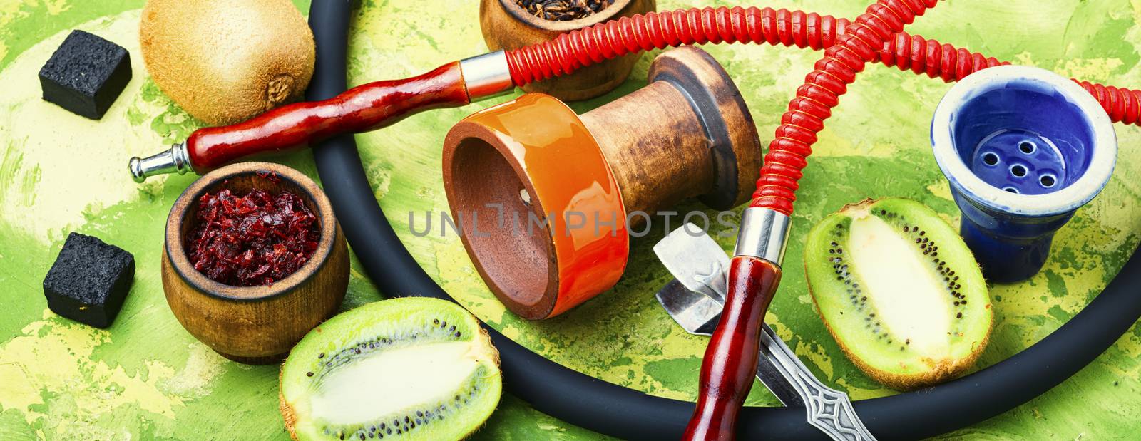 Turkish tobacco hookah on kiwi.Fragrant oriental hookah.Details of a smoking hookah.Fruit tobacco for hookah.