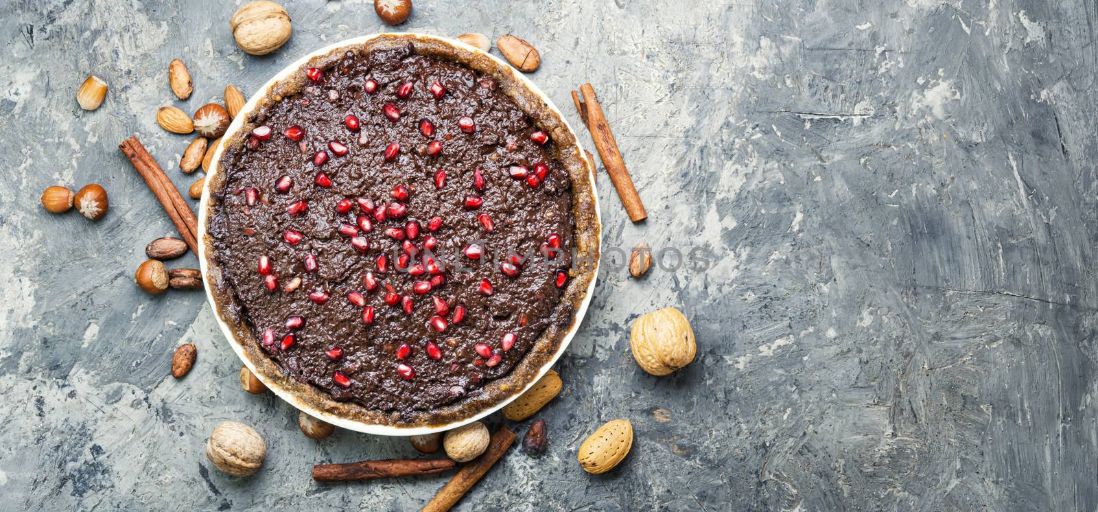 Tasty homemade chocolate cake with pomegranate and nut.Flat lay with copy space