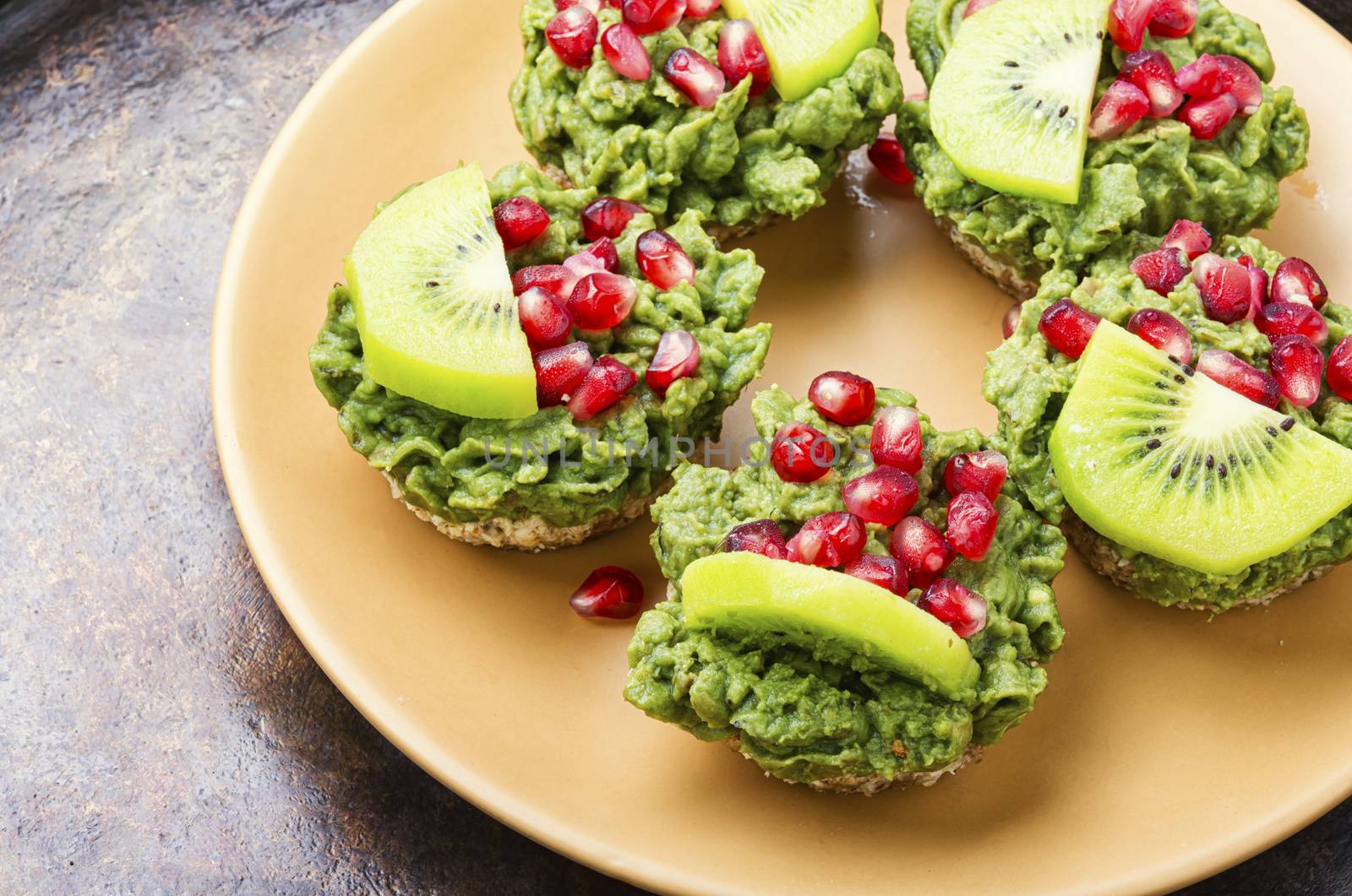 Diet avocado cupcakes garnished with kiwi and pomegranate.American food.