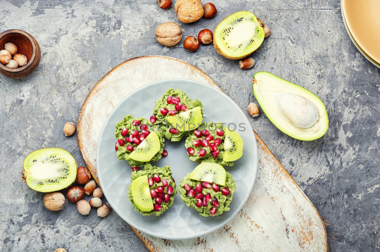 Diet avocado cupcakes garnished with kiwi and pomegranate.American fairy cake