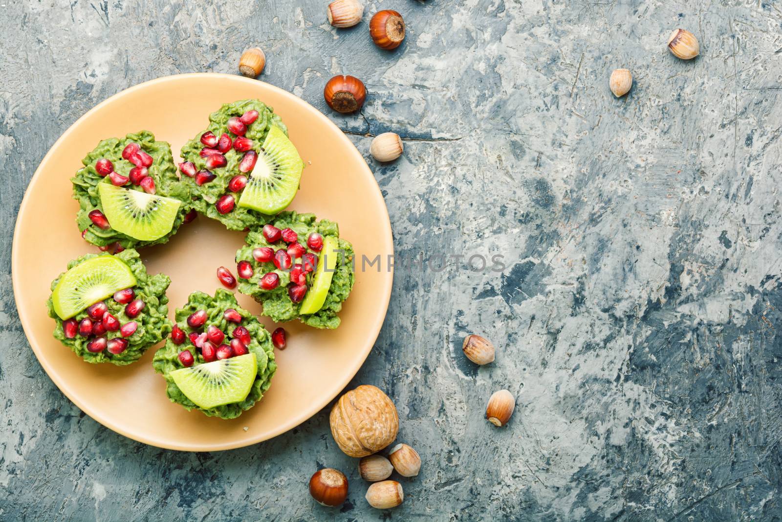 Diet avocado cupcakes garnished with kiwi and pomegranate.Fairy cake