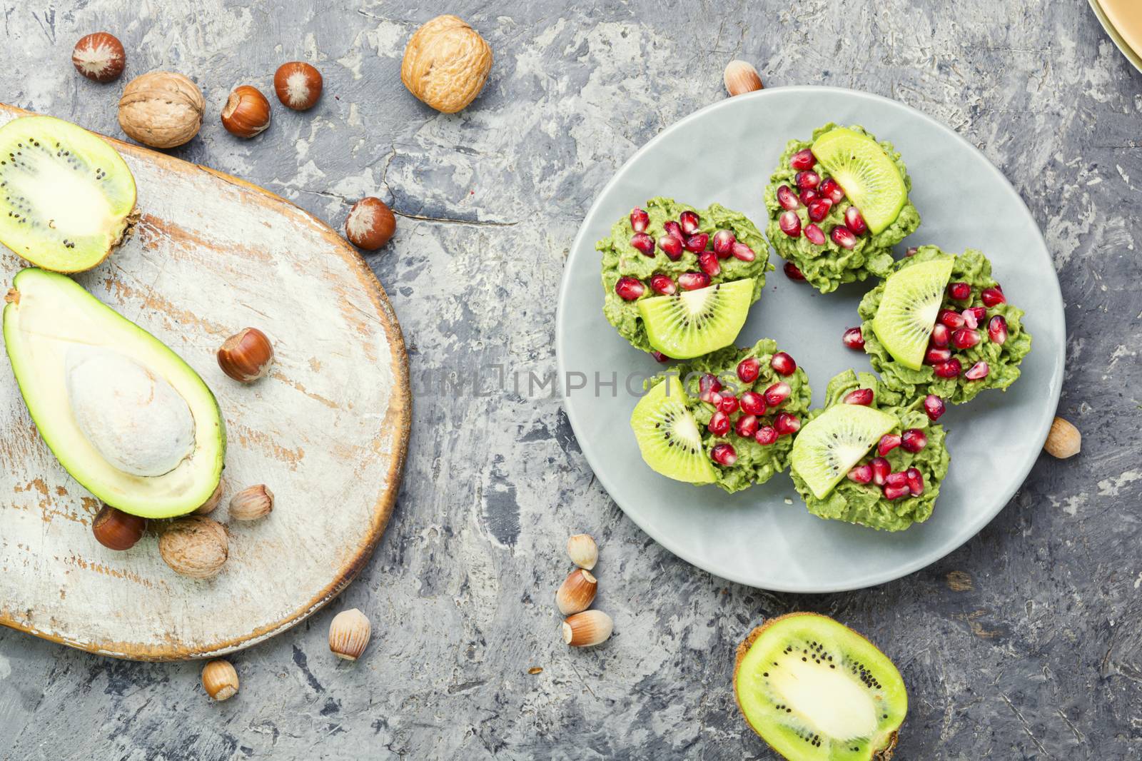 Diet avocado cupcakes garnished with kiwi and pomegranate.Fairy cake
