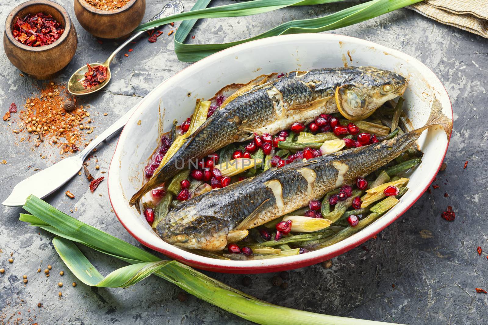 Pelengas fish baked with vegetables and pomegranate.Tasty baked whole fish.Healthy food