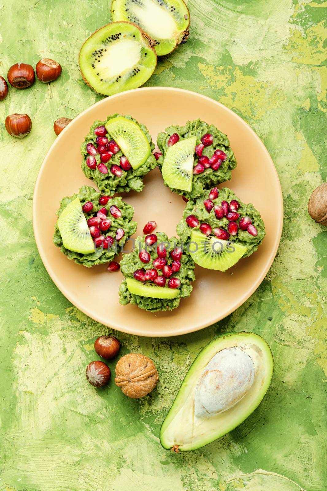 Diet avocado cupcakes garnished with kiwi and pomegranate.American fairy cake