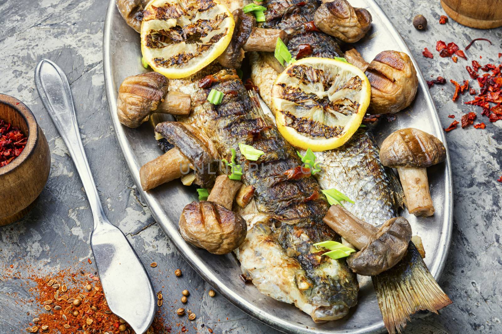 Baked whole pelengas fish with mushrooms and lemon.Sea food.Grilled fish with mushrooms.