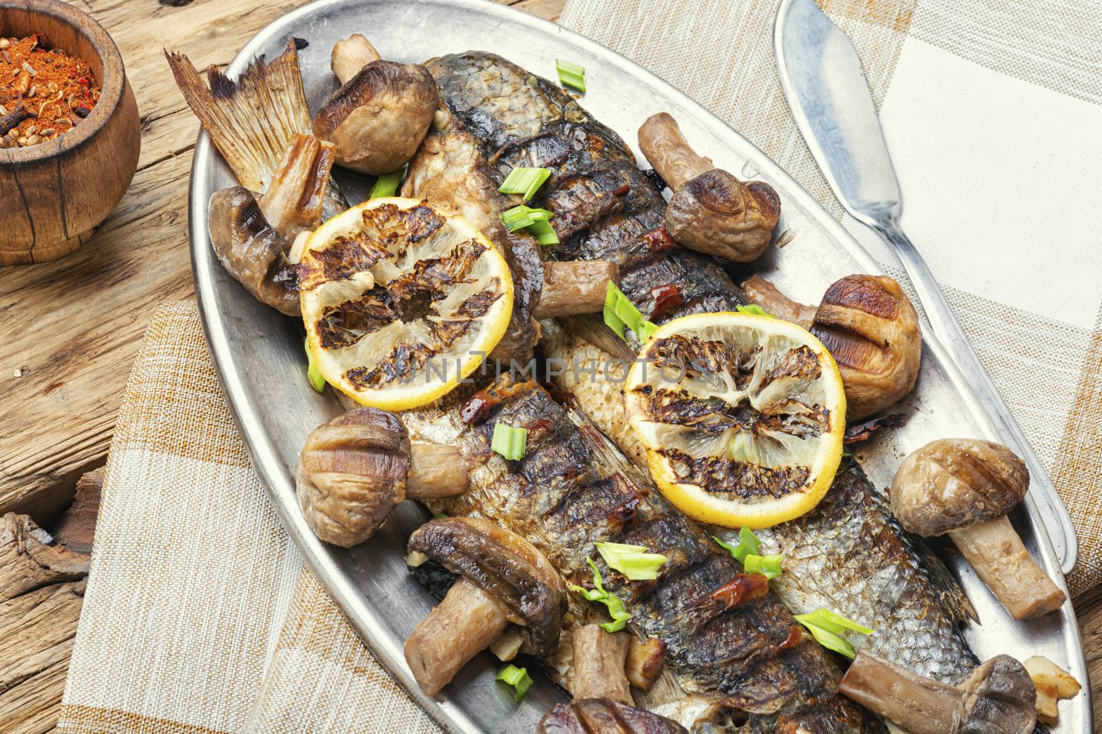 Baked whole pelengas fish with mushrooms and lemon.Sea food.Grilled fish with mushrooms.