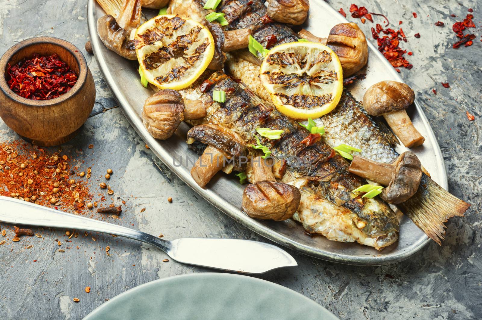Roasted pelengas fish with mushrooms and lemon.Sea food.Grilled fish with champignon