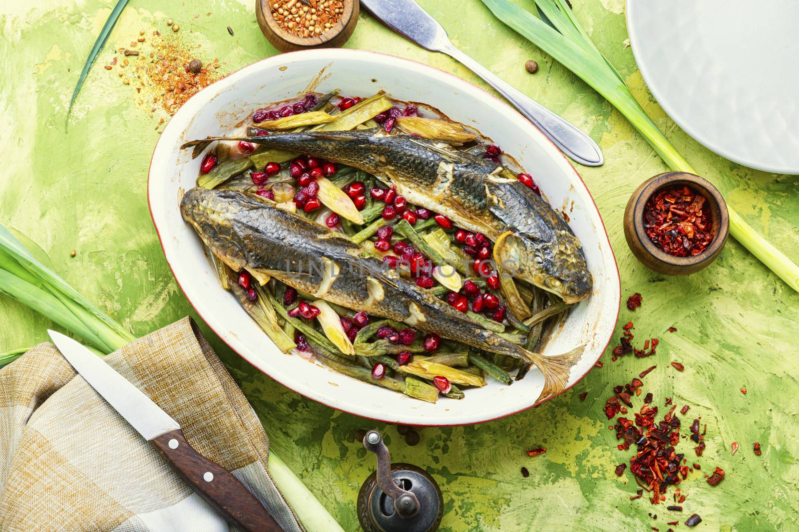 Pelengas baked with vegetables and pomegranate.Tasty baked whole fish
