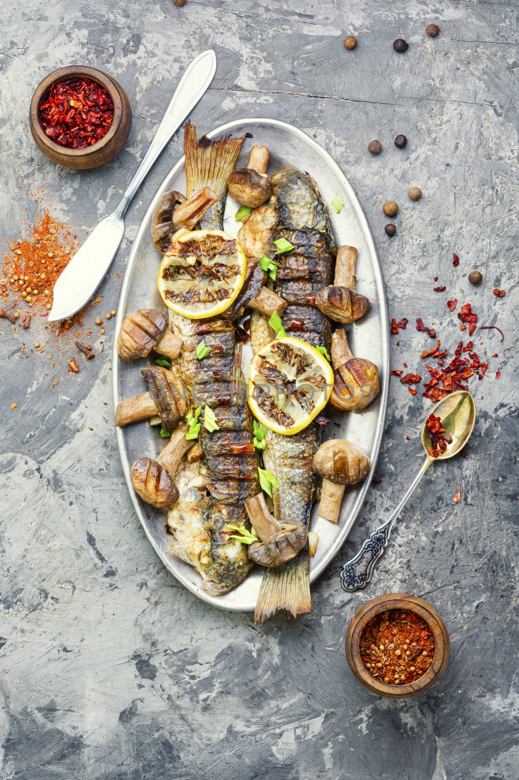 Baked whole pelengas fish with mushrooms and lemon.Sea food.Grilled fish with mushrooms.