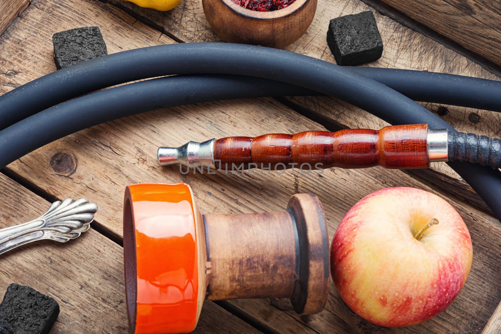 Preparation of a smoking hookah.Oriental hookah with a fruit aroma.Hookah on an apple.