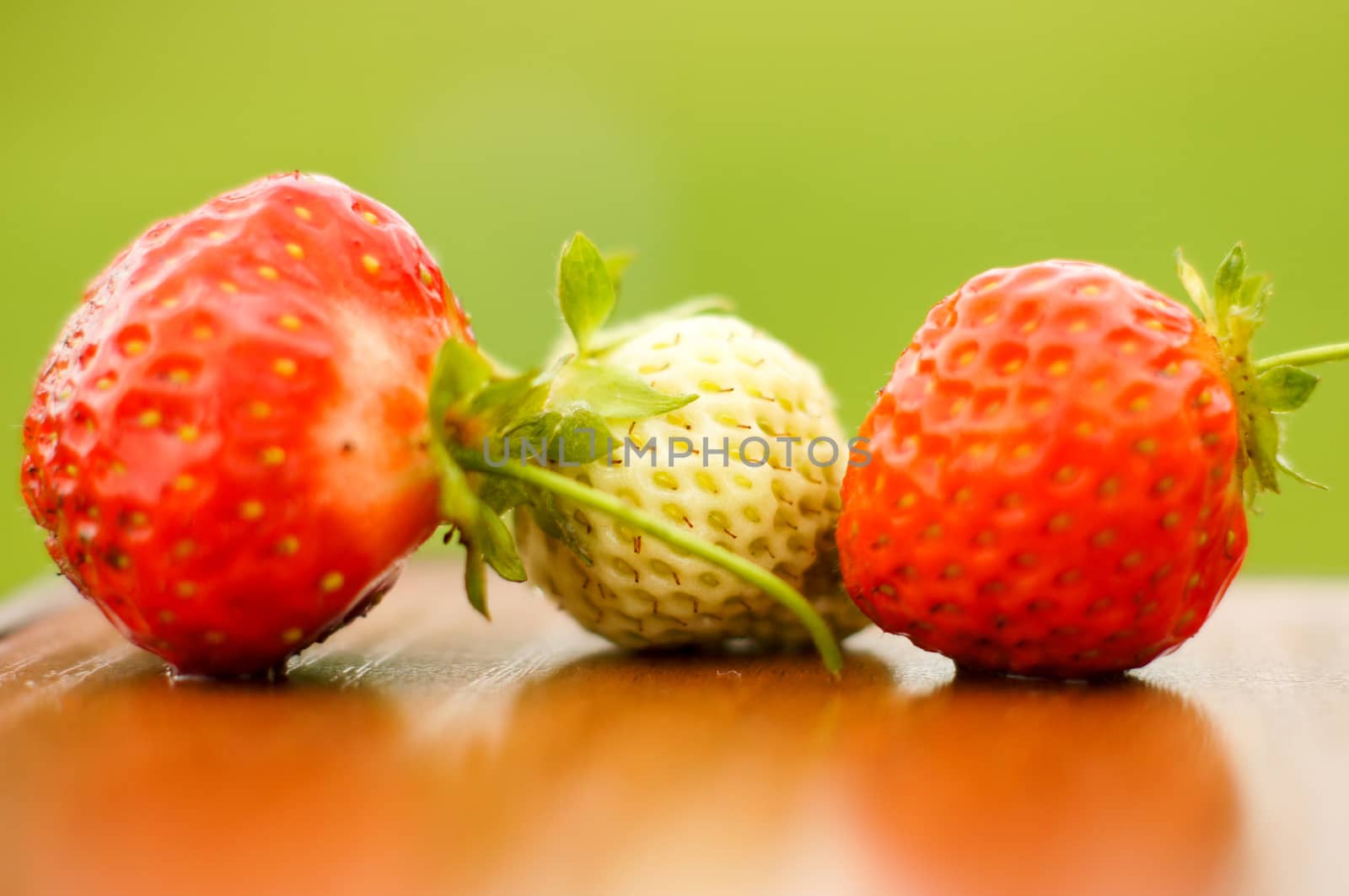 White and red strawberries lie in the sun. Delicious and sweet dessert berry. Vitamins by Adamchuk