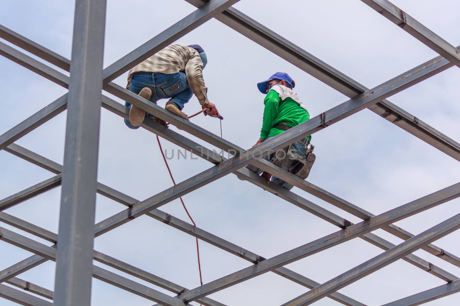 Welder welding fabricated construction in building, Welding process by Stick Welding, No safety Belt, No Mask, No Glove