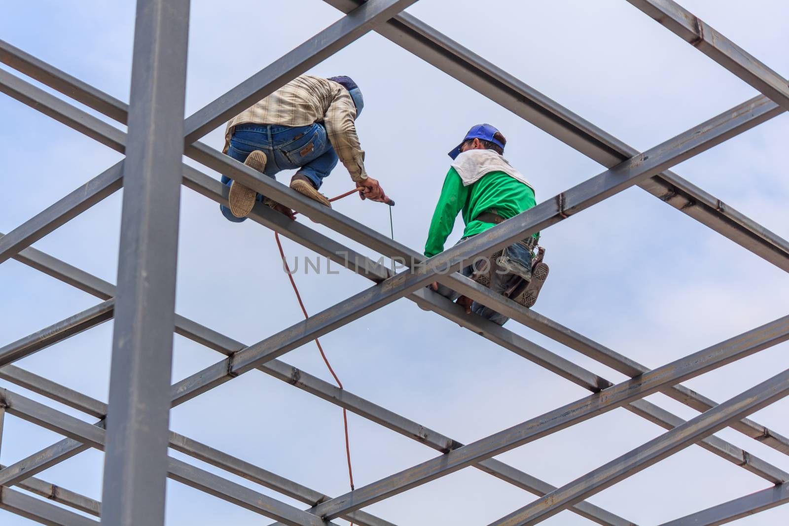 Welder welding fabricated construction in building, Welding process by Stick Welding, No safety Belt, No Mask, No Glove