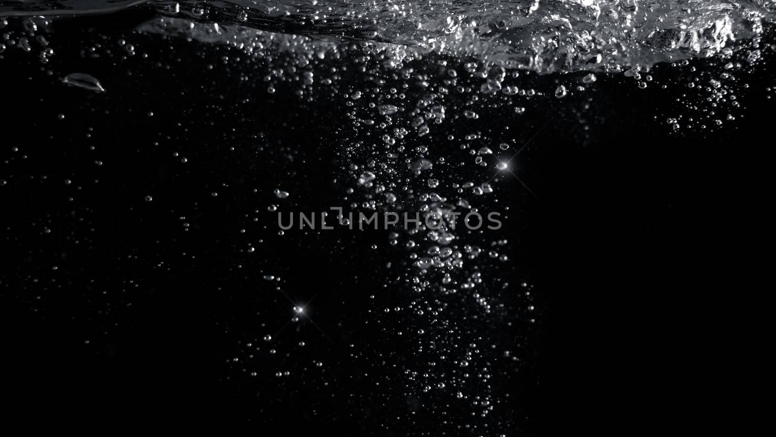Blurred images of close-up soda water bubbles fizzing up or splashing or sparkling like a exploding of a bomb on black background for represent refreshing from carbonated drinks menu.