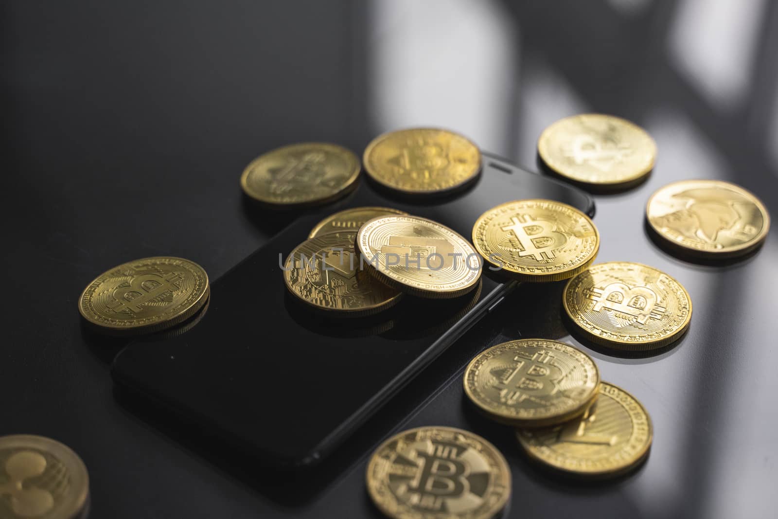 Stack of golden Dash bitcoin coin on a smartphone with a lot of bitcoins coins on a table. Virtual cryptocurrency concept. Mining of bitcoins online bussiness. Bitcoins trading