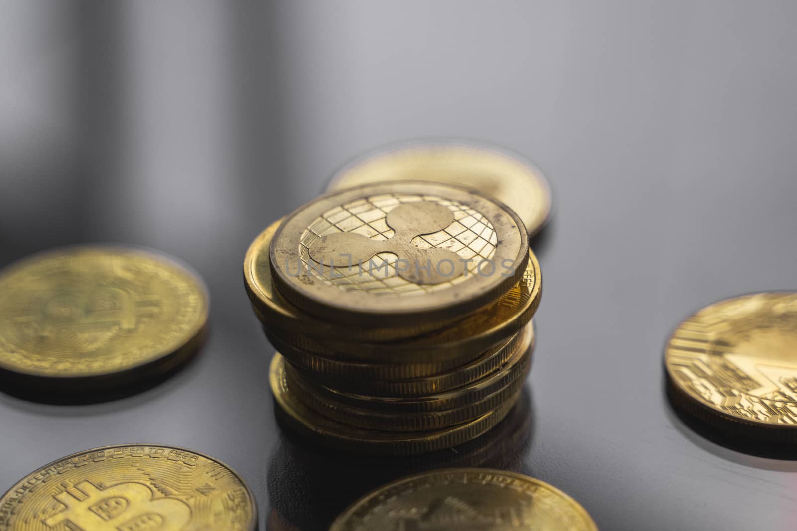 Stack of golden Ripple bitcoin coin with a lot of bitcoins coins on a table. Virtual cryptocurrency concept. Mining of bitcoins online bussiness. Bitcoins trading