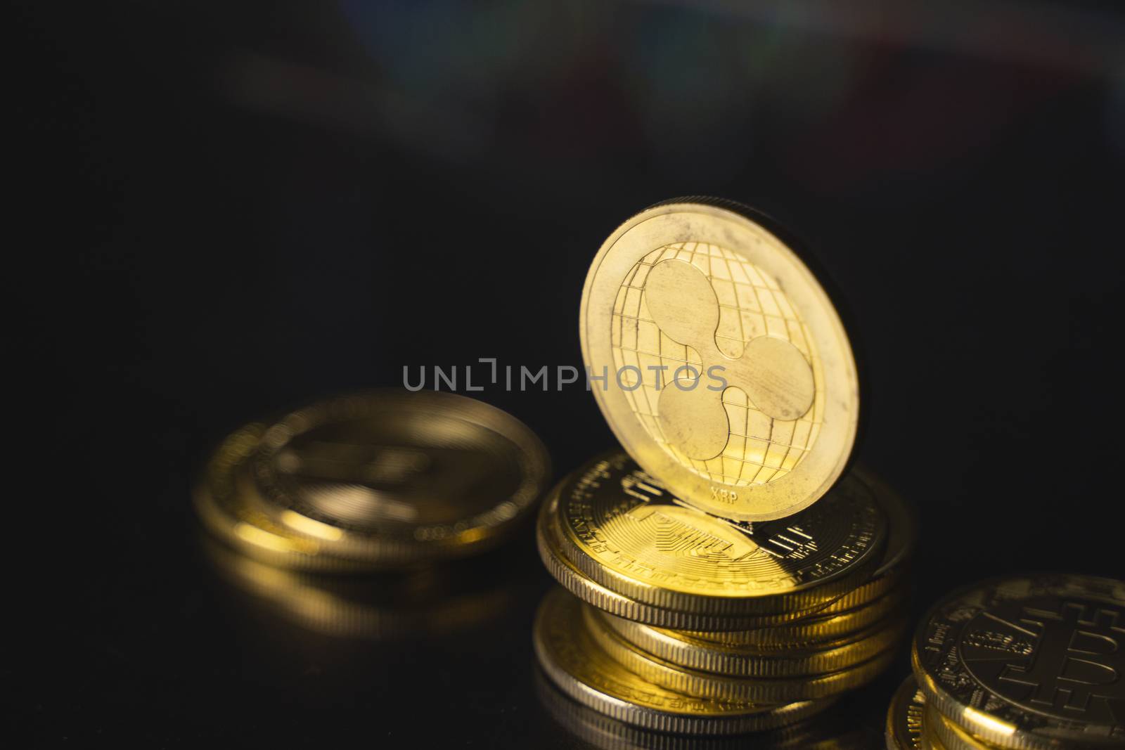 Ripple coin and virtual money concept. Gold Ripple on a stack of coins with chart of growing and falling valuance of a cryptocurrency. Mining or blockchain technology. by vovsht