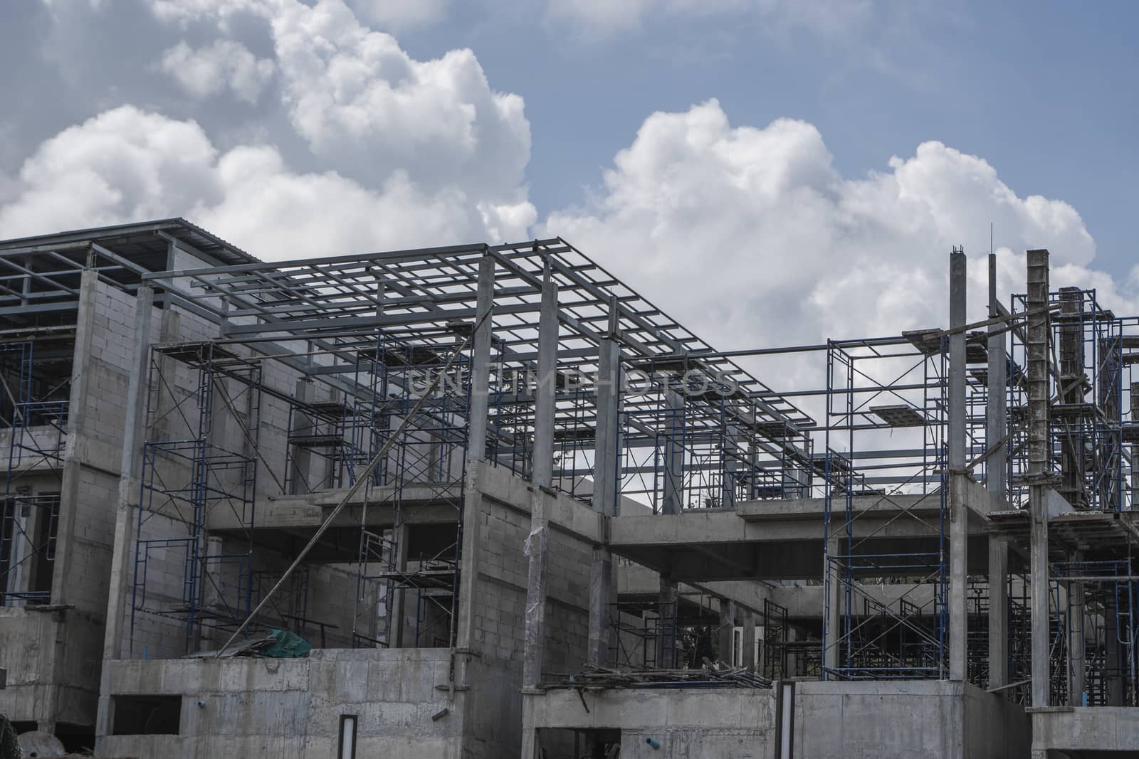 Building and Construction Site in progress. Building construction site against cloudy sky. Metal construction of unfinished building on construction of multi storage building. by vovsht