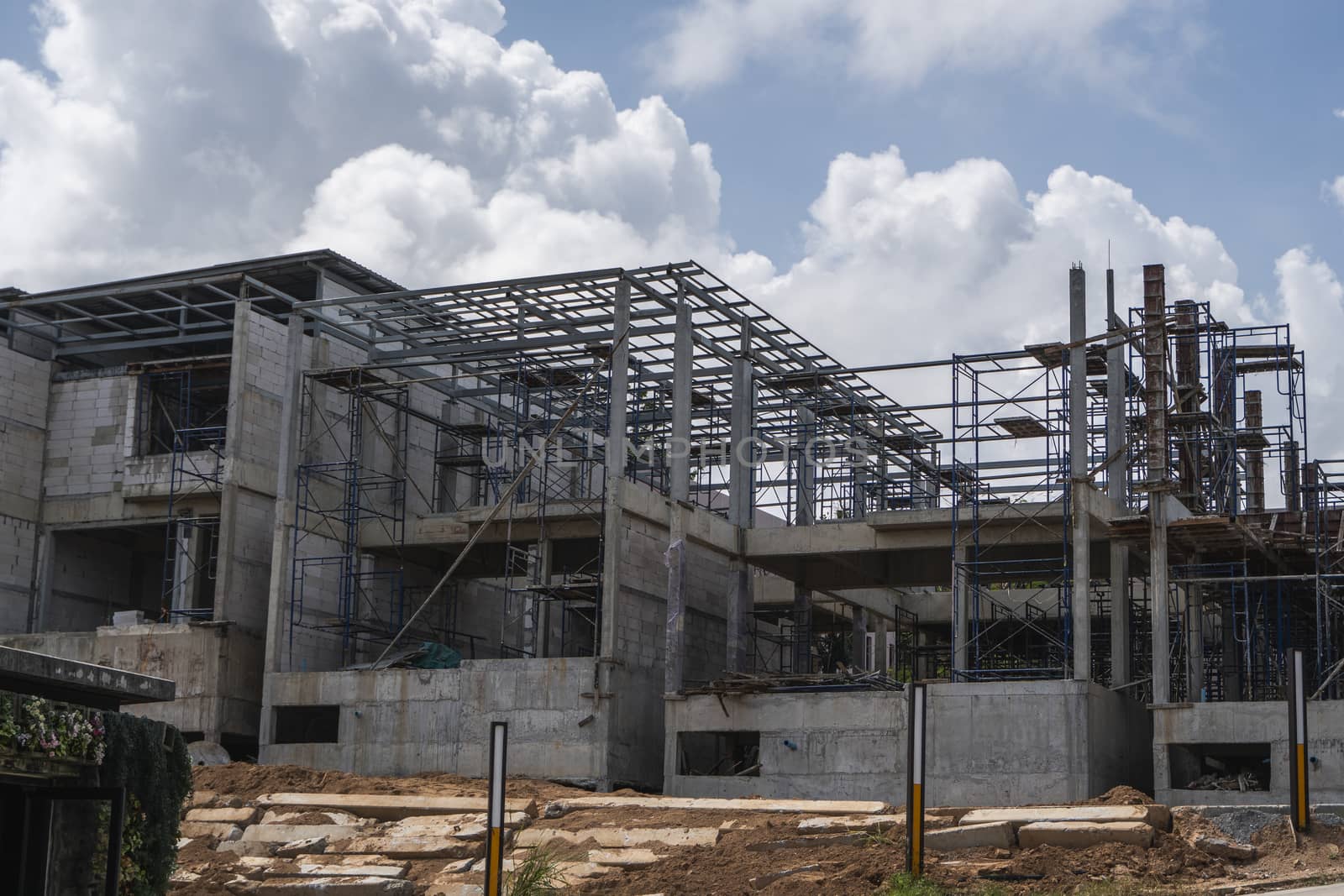 Building and Construction Site in progress. Building construction site against cloudy sky. Metal construction of unfinished building on construction of multi storage building