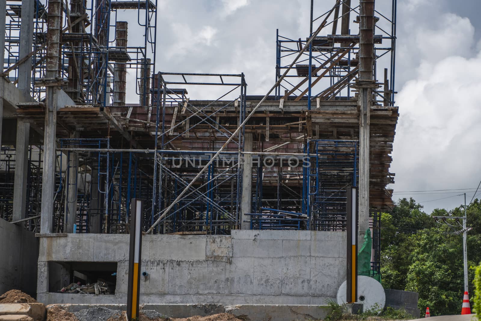 Building and Construction Site in progress. Building construction site against cloudy sky. Metal construction of unfinished building on construction of multi storage building