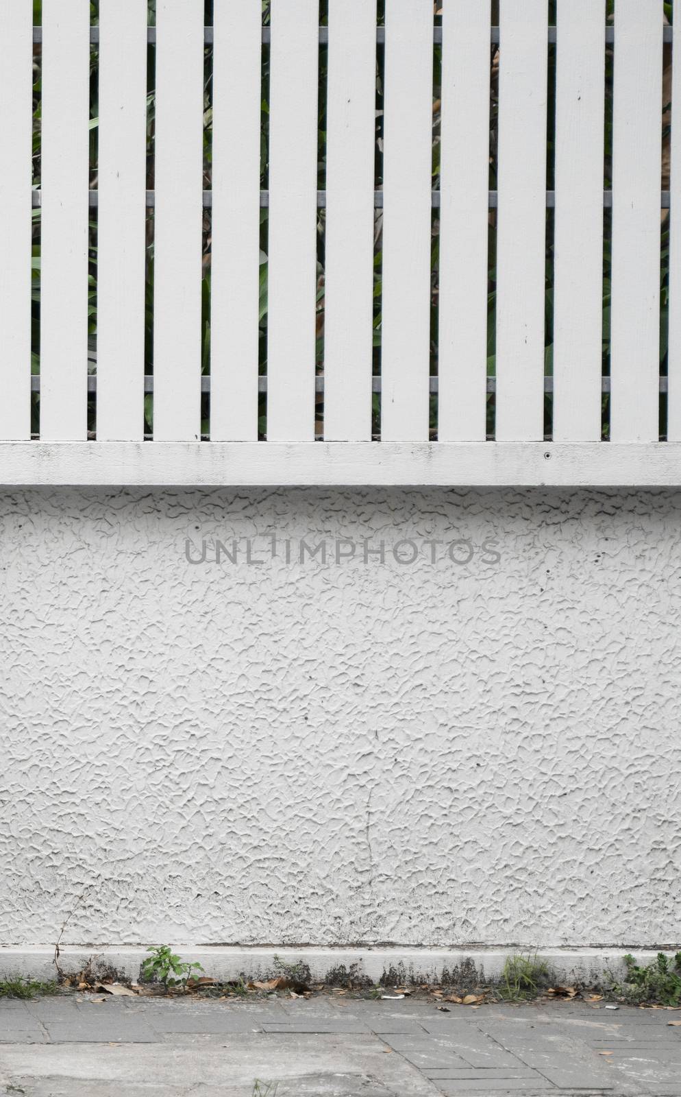 White concrete wall with a wood fence on a street. by vovsht