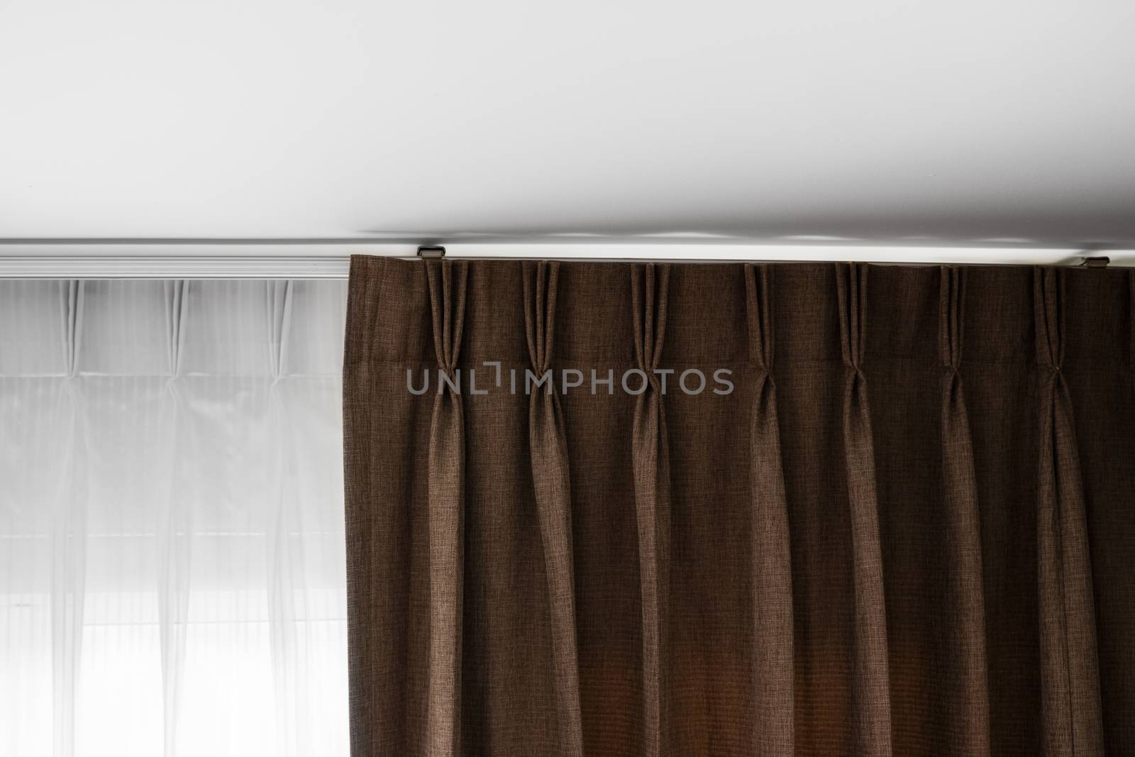 Brown curtains and white tulle on a rail with a white ceiling. Curtain interior decoration in living or sleeping room. Comfortable live in your own home. Sweet confy home. by vovsht