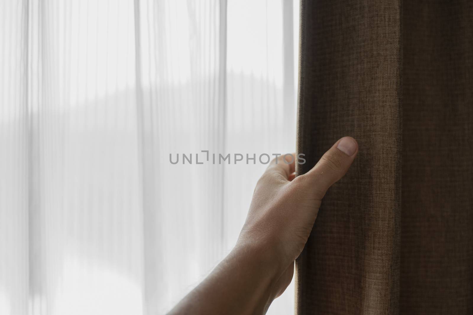 Men hand opening curtain in bed room