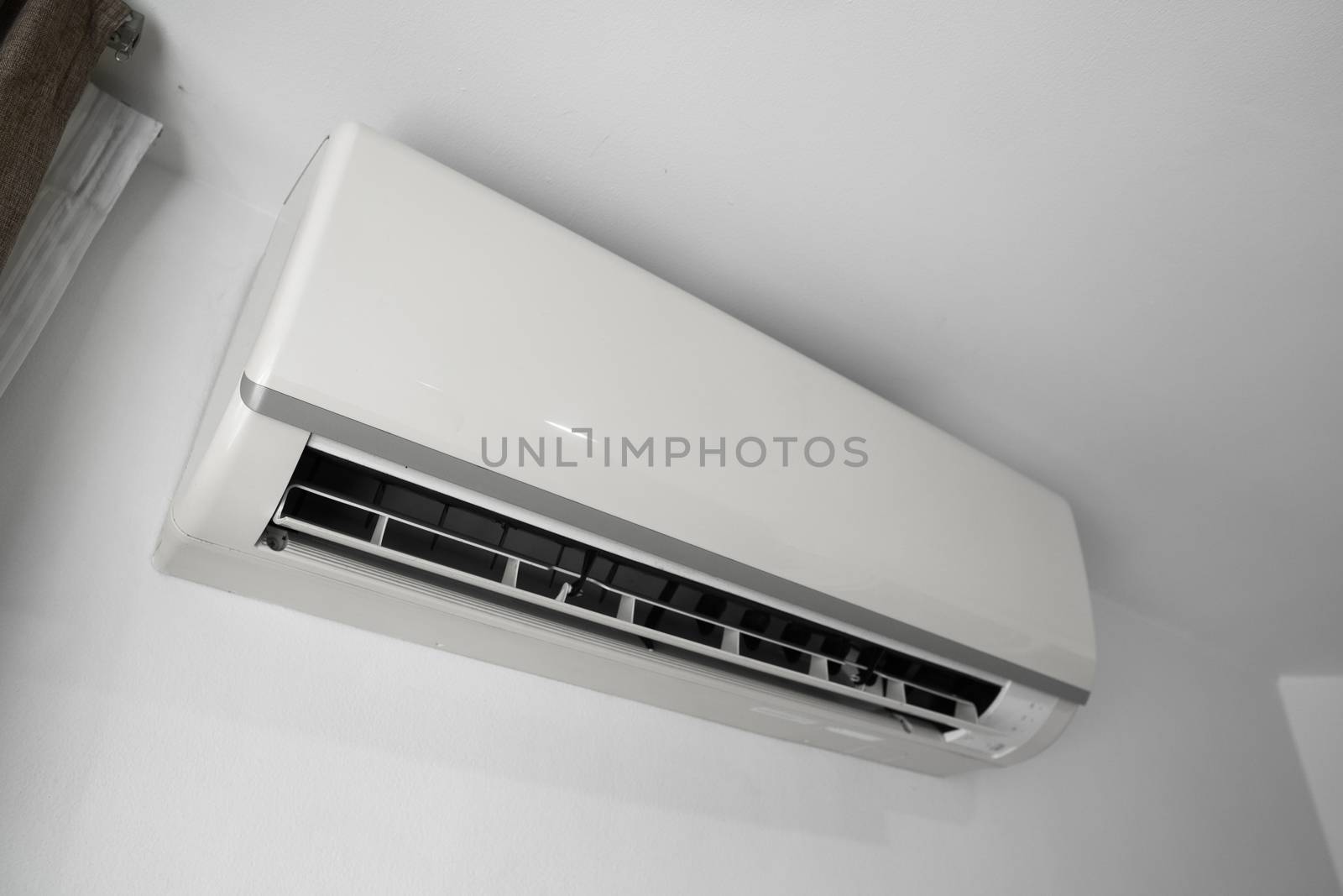 Air conditioner mounted on a white wall in the living room or bedroom. Indooor comfort temperature. Health concepts and energy savings