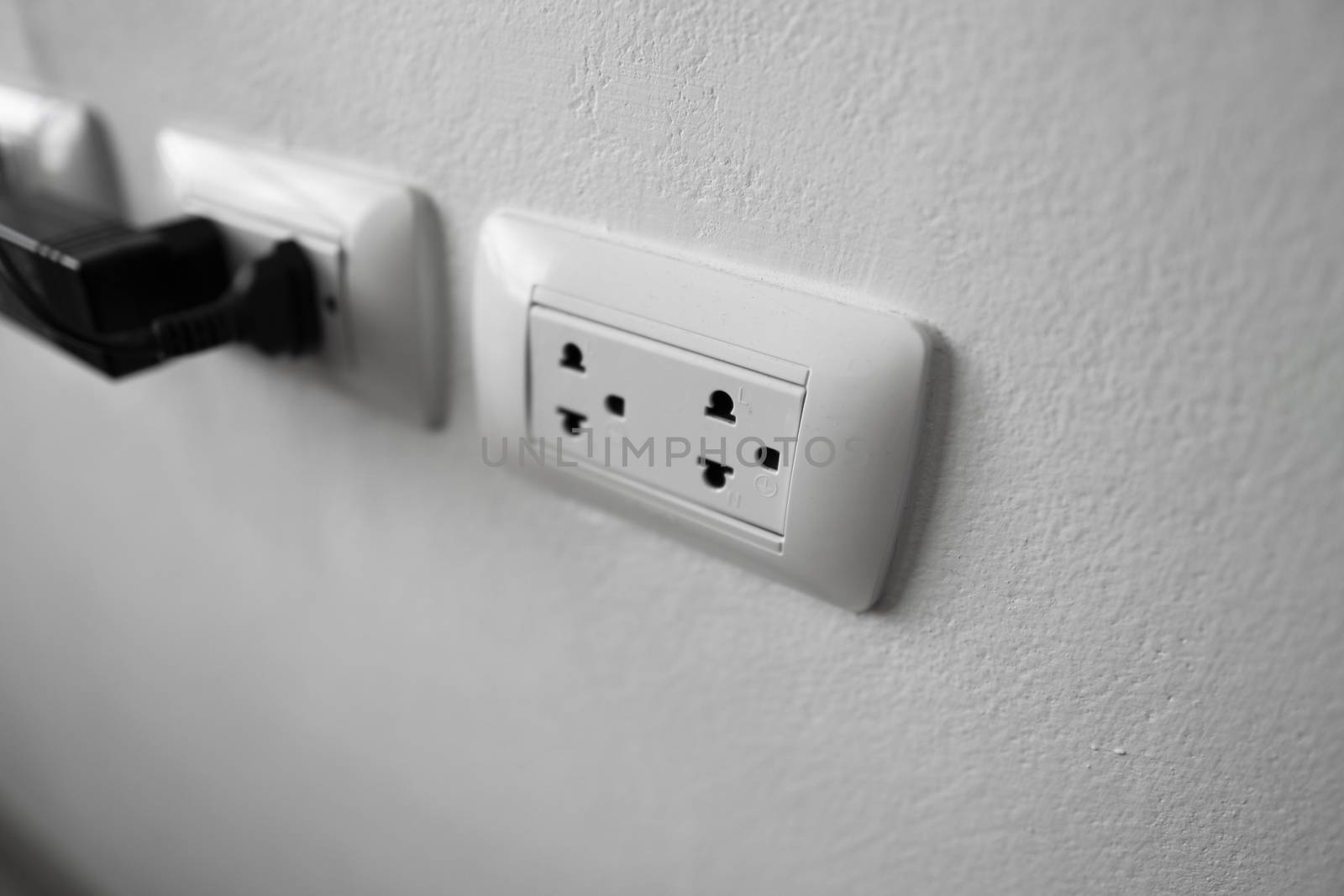 White universal electricity sockets plug on a white wall