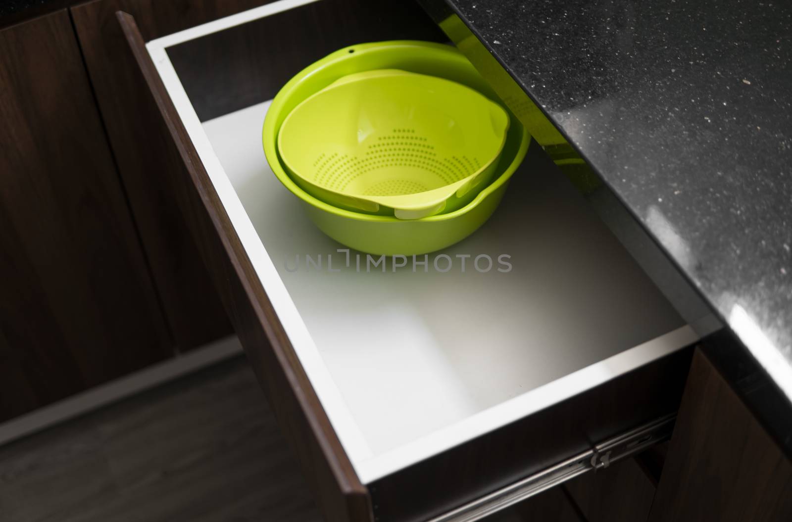 Green salad bowl and bowl for straining food from water in the kitchen drawer