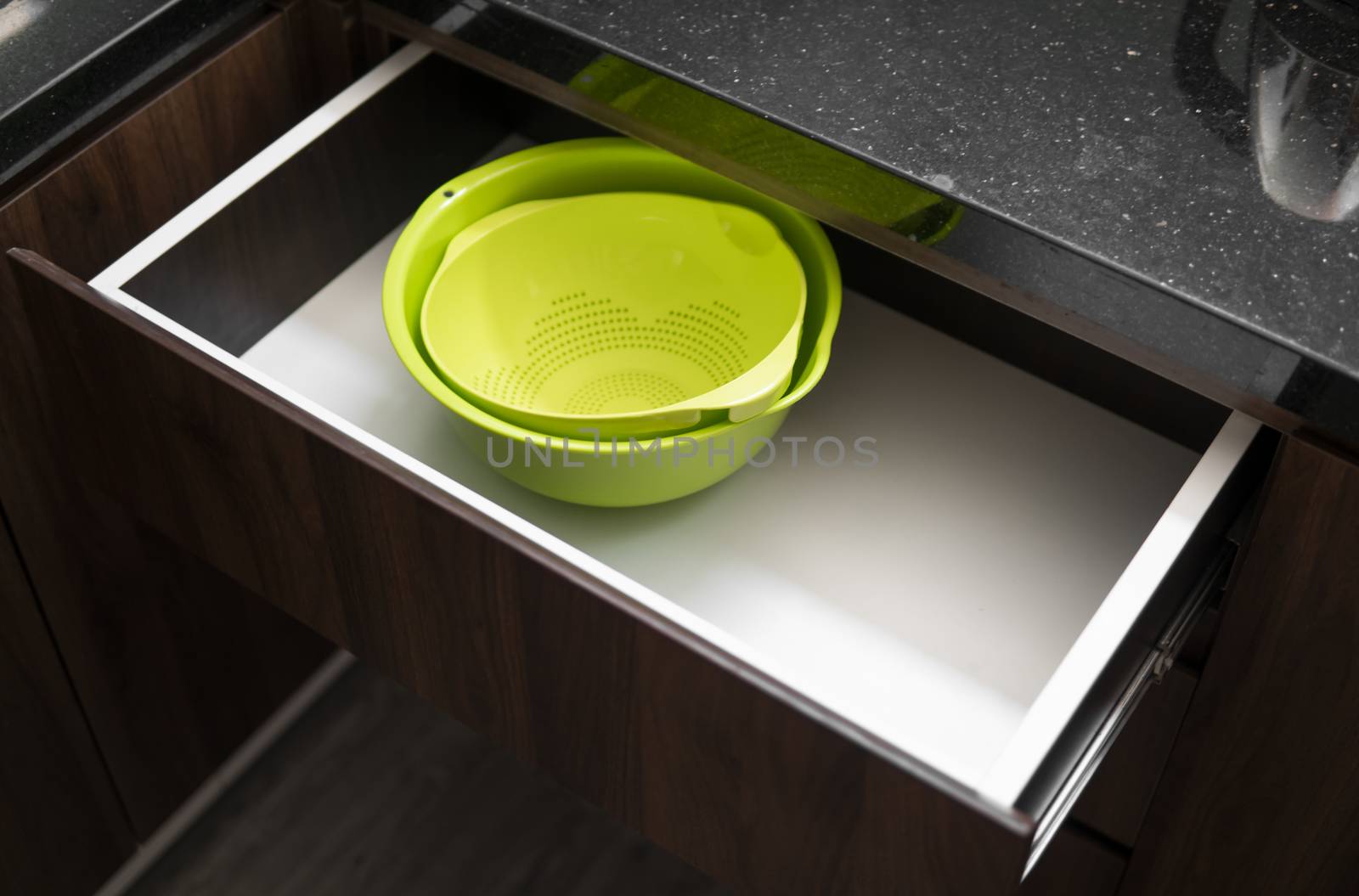 Green salad bowl and bowl for straining food from water in the kitchen drawer. by vovsht