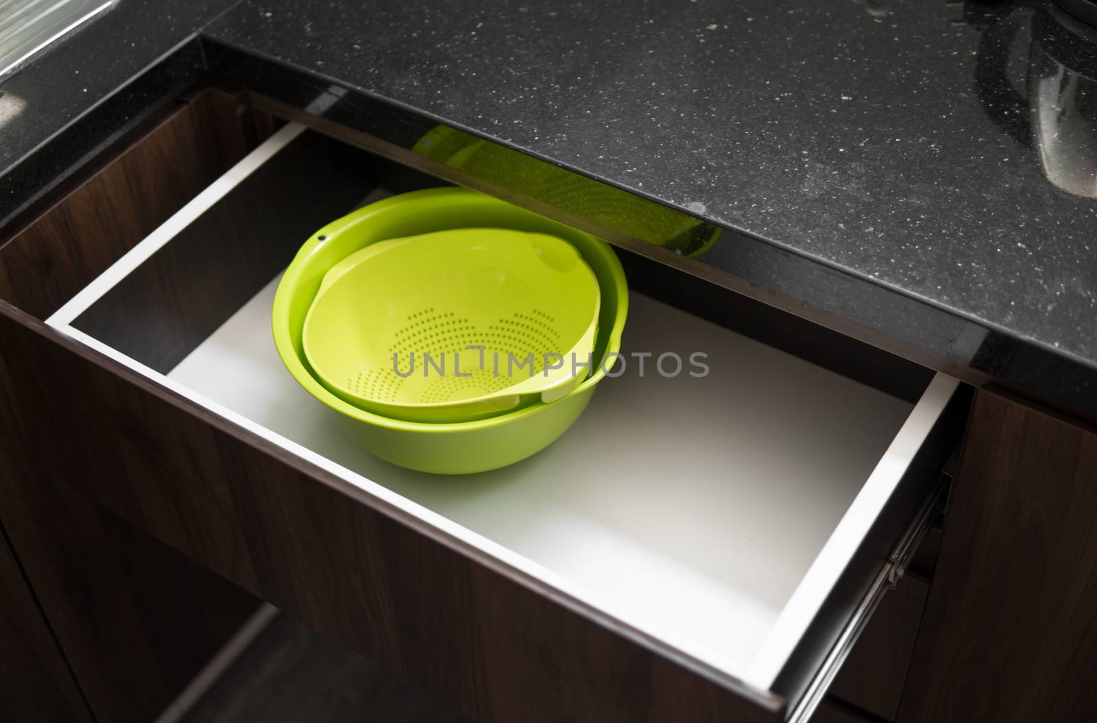 Green salad bowl and bowl for straining food from water in the kitchen drawer