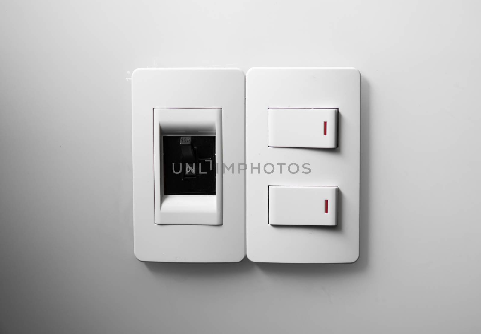 White switch on a white wall with two switches and one common switch. by vovsht