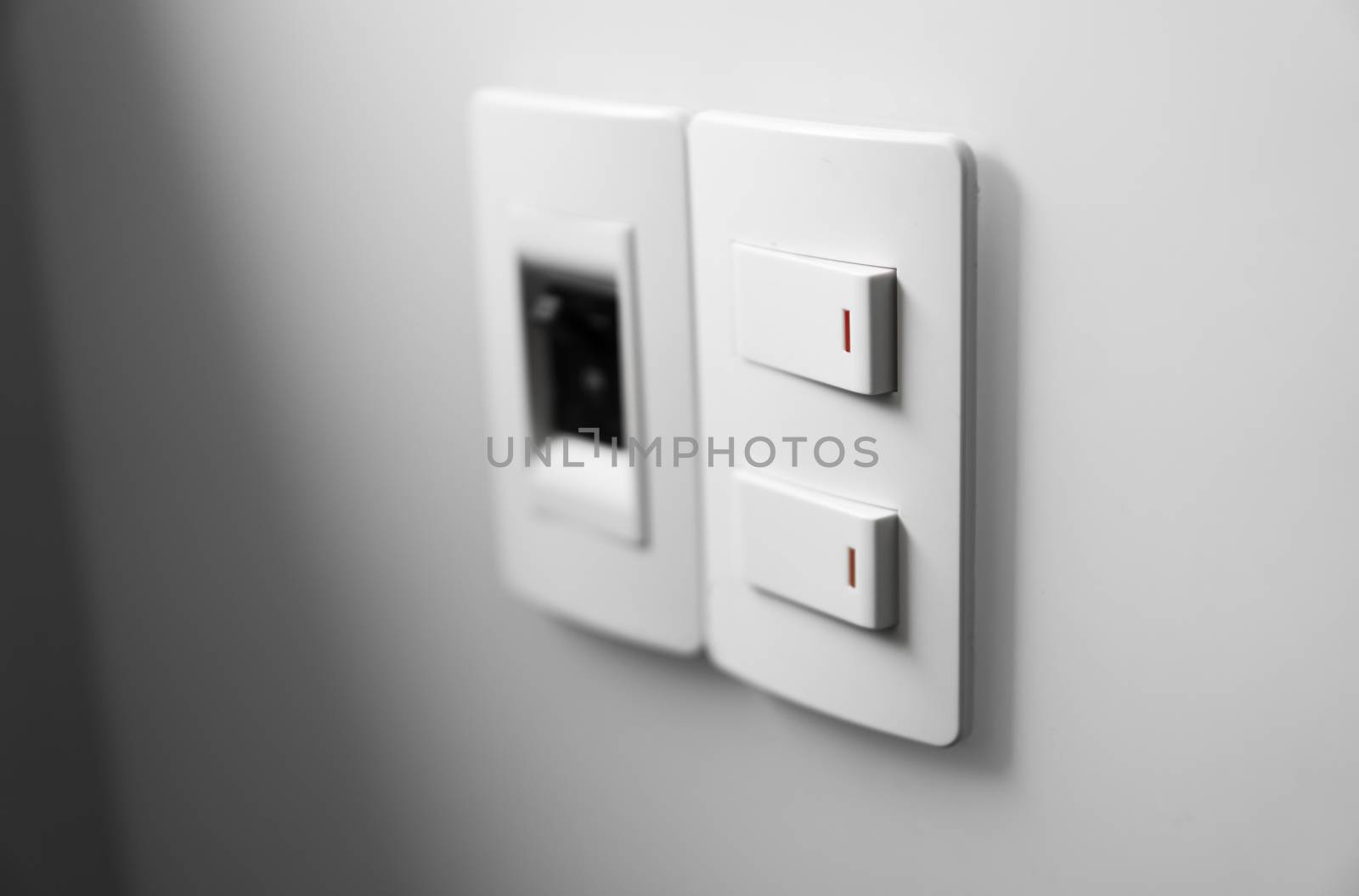 White switch on a white wall with two switches and one common switch. by vovsht