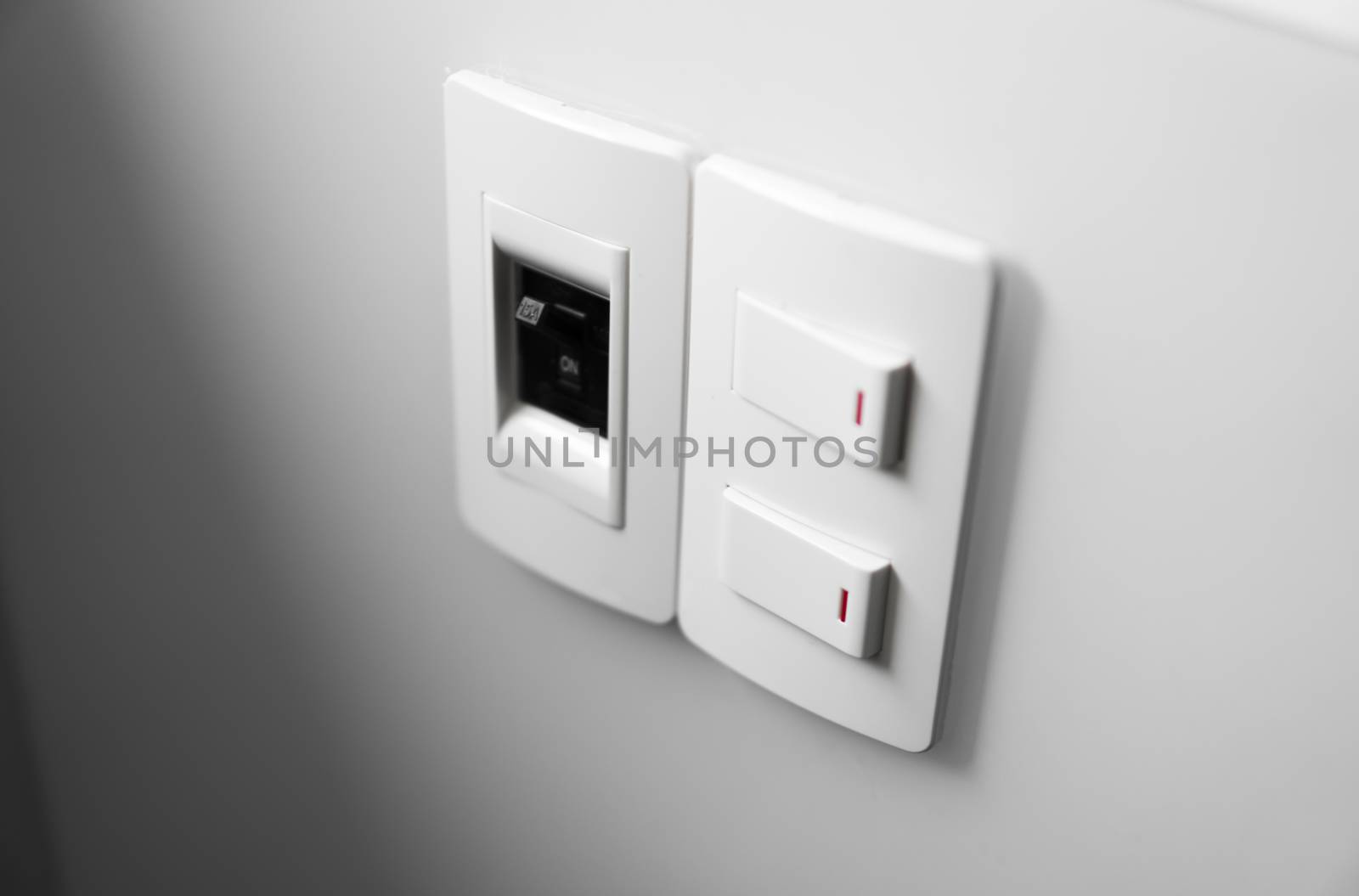 White switch on a white wall with two switches and one common switch. by vovsht