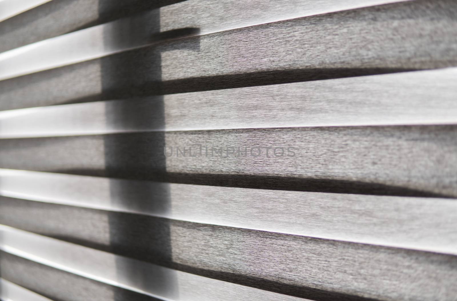 Details of brown fabric roller blinds on the plastic window with wood texture in the living room. by vovsht