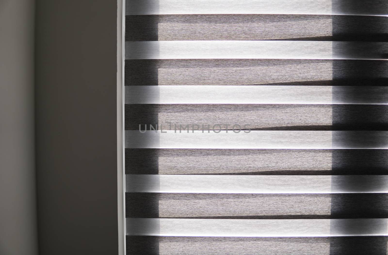 Details of brown fabric roller blinds on the plastic window with wood texture in the living room