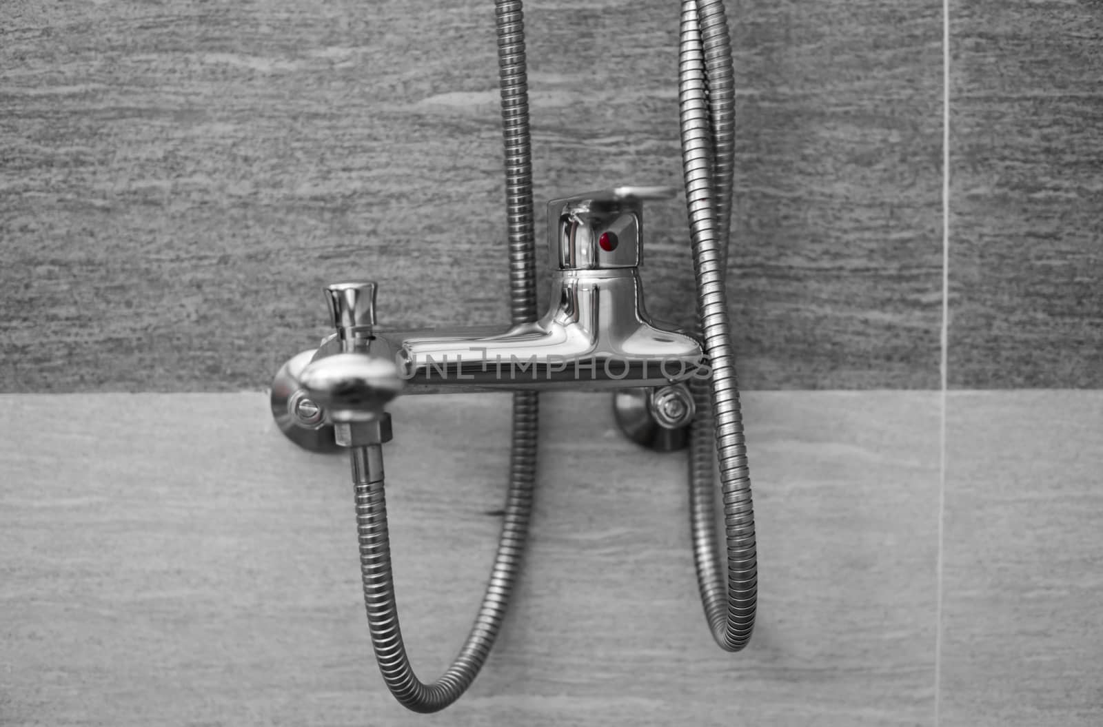 Modern designer tap and shower in bathroom. Closeup of chrome shower, faucet, in the bathroom covered decorative ceramic. Mixer cold hot water. by vovsht