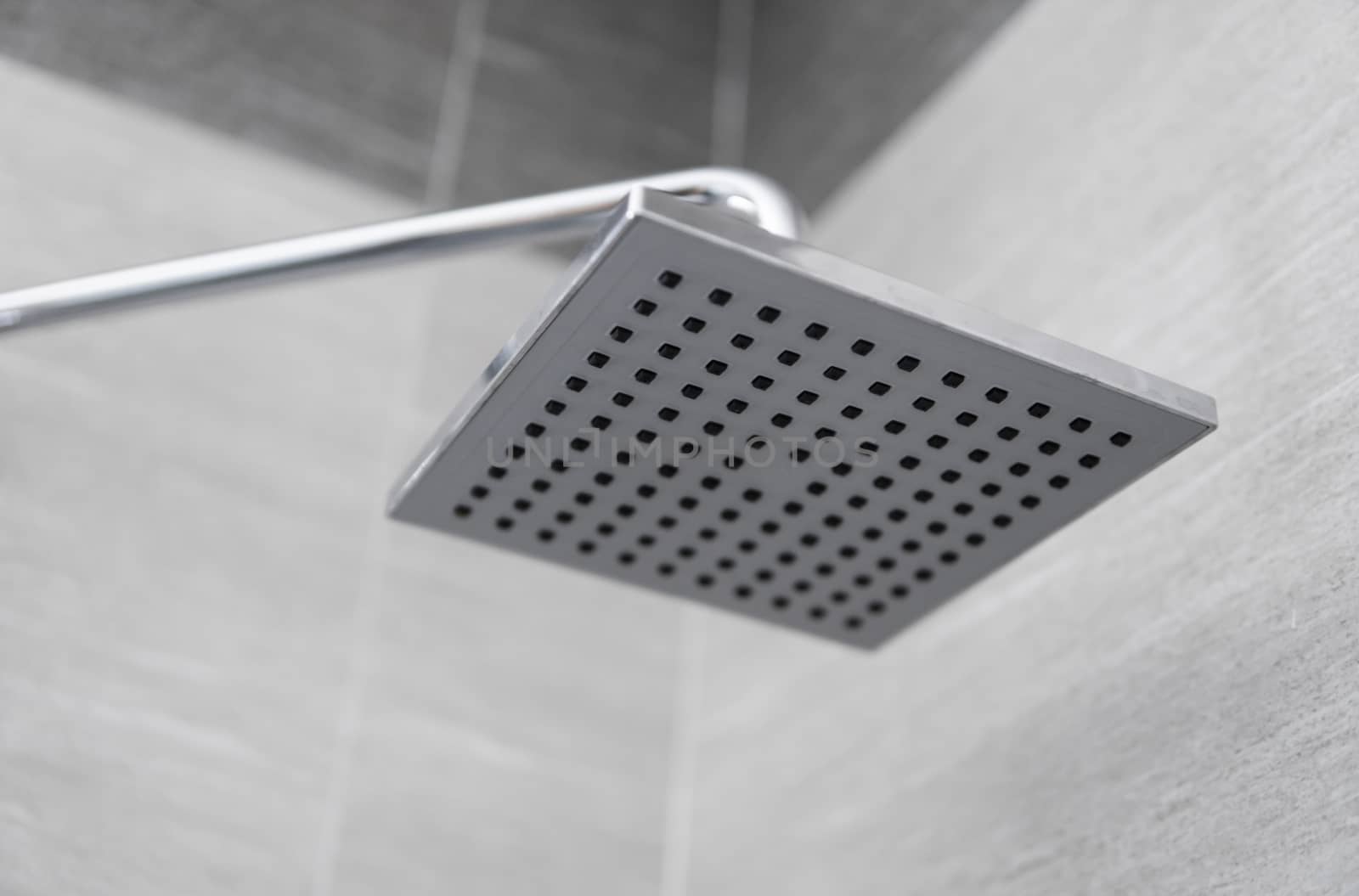 Square shower head in a modern bathroom. Shower in the bathroom with water spray or water. Feel relaxed and enjoy in the bathroom. A stream of fresh water from the shower head to clean the dirty body. by vovsht