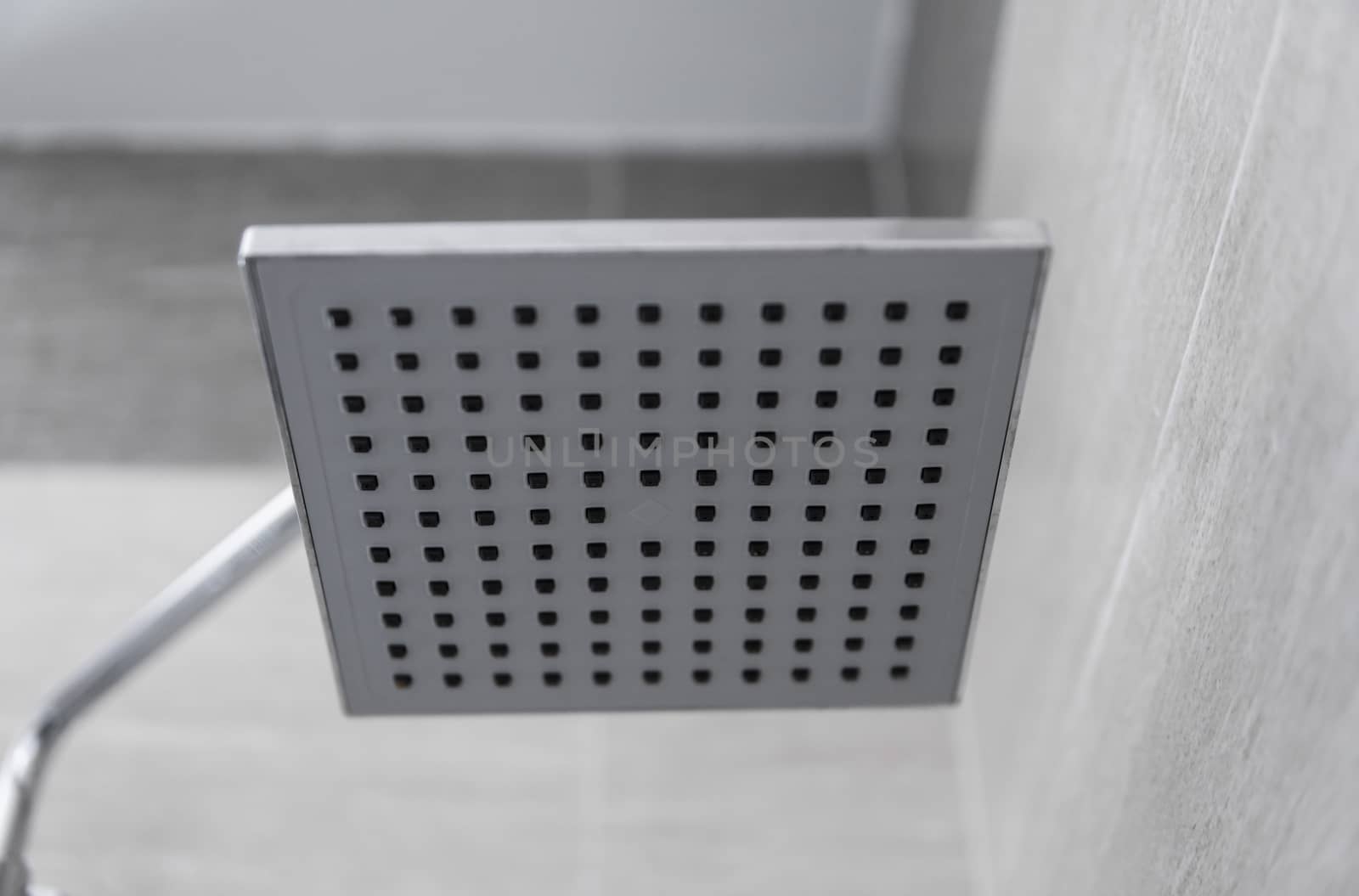 Square shower head in a modern bathroom. Shower in the bathroom with water spray or water. Feel relaxed and enjoy in the bathroom. A stream of fresh water from the shower head to clean the dirty body. by vovsht