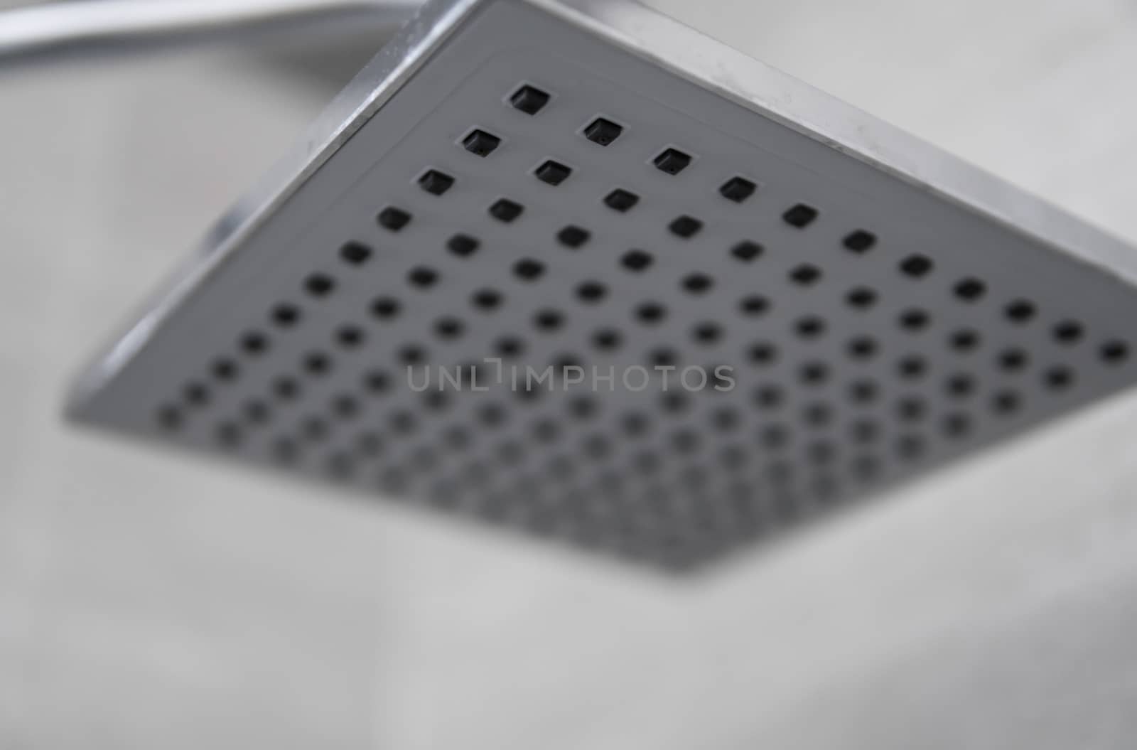 Square shower head in a modern bathroom. Shower in the bathroom with water spray or water. Feel relaxed and enjoy in the bathroom. A stream of fresh water from the shower head to clean the dirty body. by vovsht