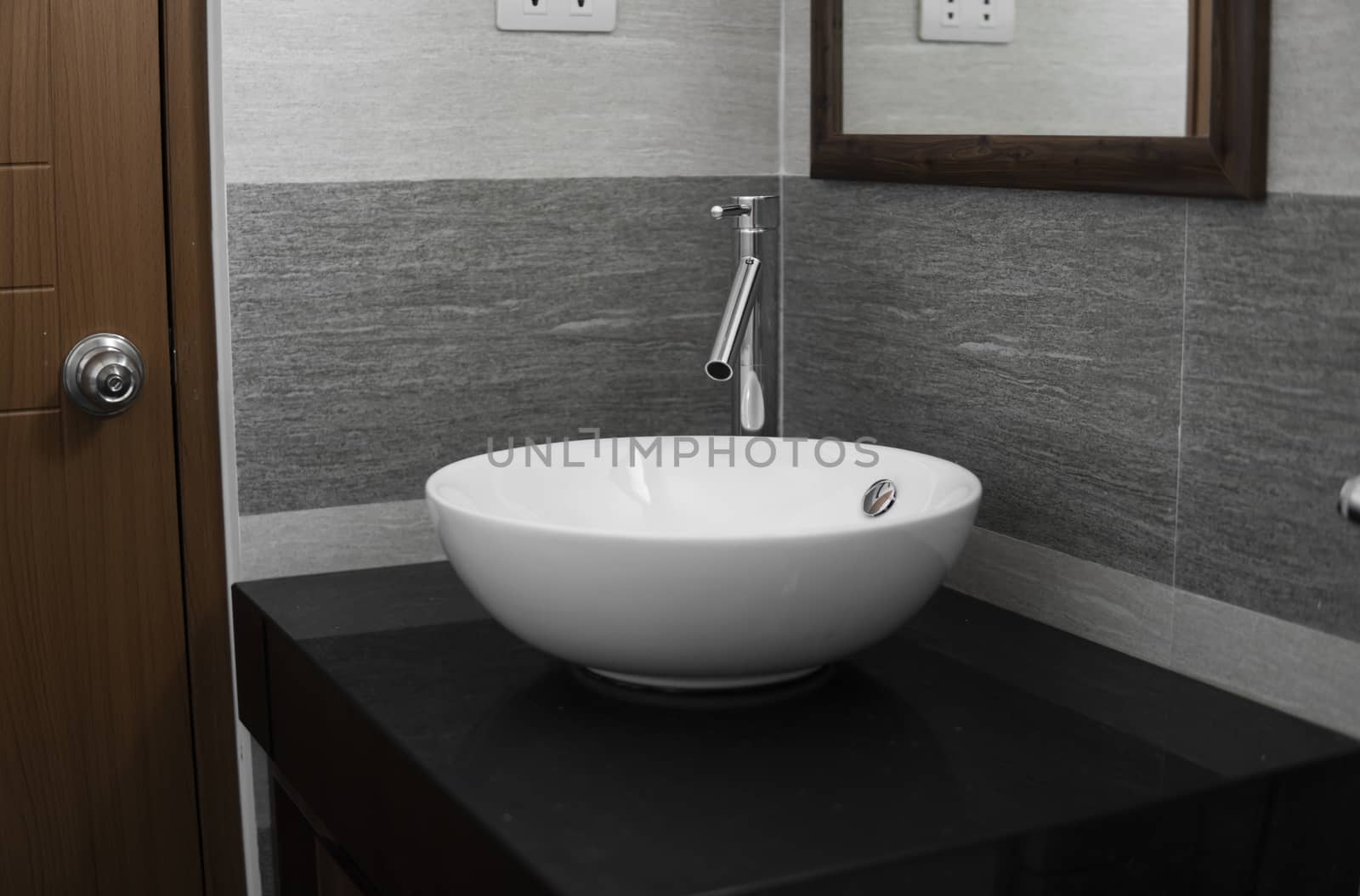 Bathroom interior with white round sink and chrome faucet in a modern bathroom