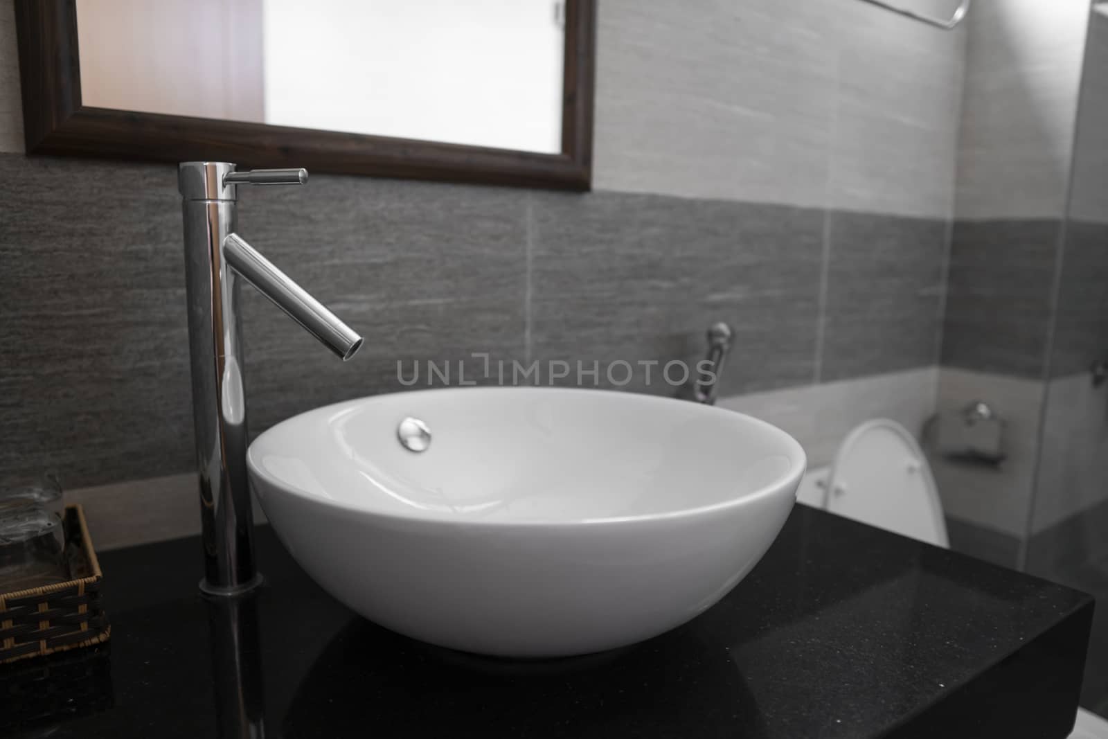 Bathroom interior with white round sink and chrome faucet in a modern bathroom