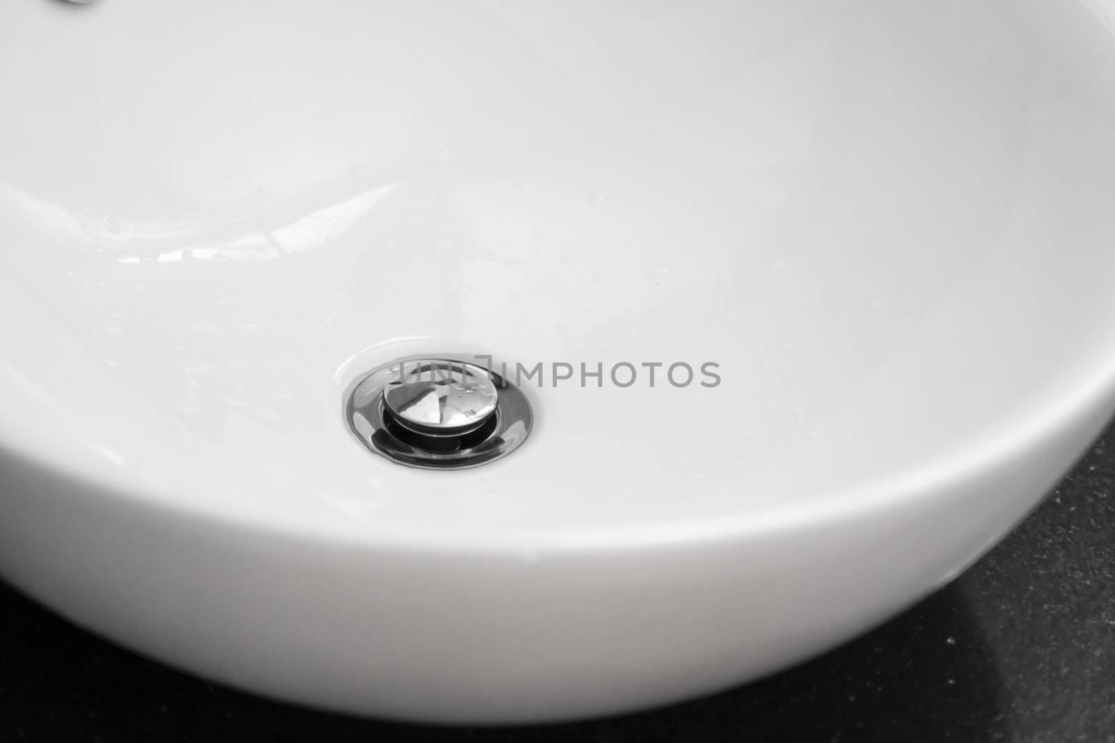 Bathroom interior with white round sink and chrome faucet in a modern bathroom